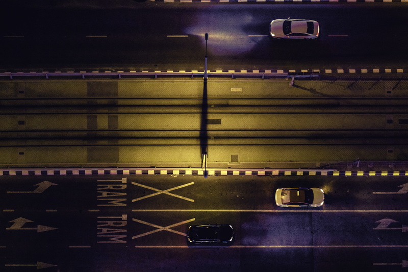 birds eye view, sign, road marking, parking garage, dark, symbol, cars, indoors, marking, aerial, motor vehicle, pattern, land vehicle, architecture, motion