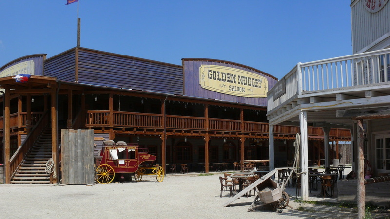 mode of transportation, sign, built structure, city, western script, wild west, daytime, communication, sky, nonamecity, ghost town, business, painted