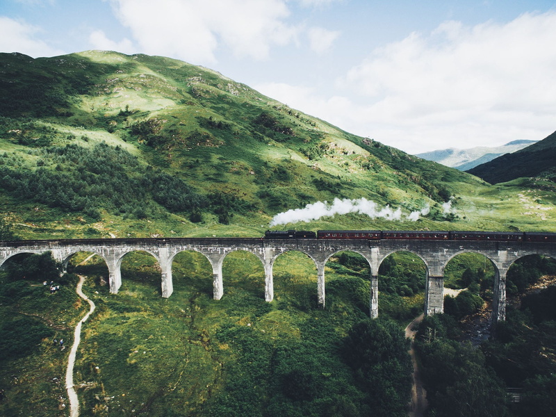 beauty in nature, tranquil scene, train, architecture, arch, sky, water, landscape, mountains, tree, bridge, no people, green color, built structure, scenics - nature