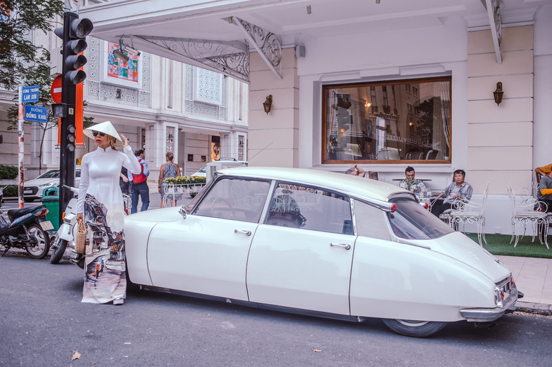 day, event, automobile, land vehicle, road, real people, daylight, outdoors, adult, transportation system, car, vietnam, street, ao dai, people, transportation