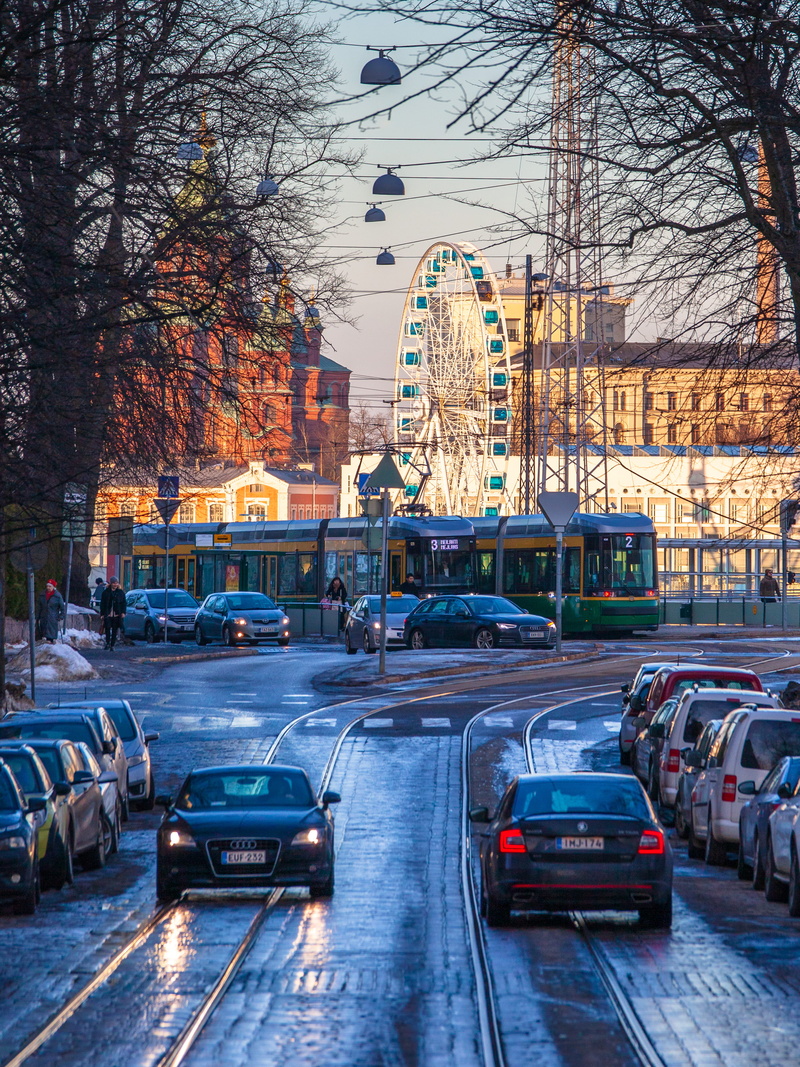 tram, building exterior, street, road, city life, vehicle, city, car, uspenski cathedral, tree, traffic jam, person, trams, human, sunset, built structure