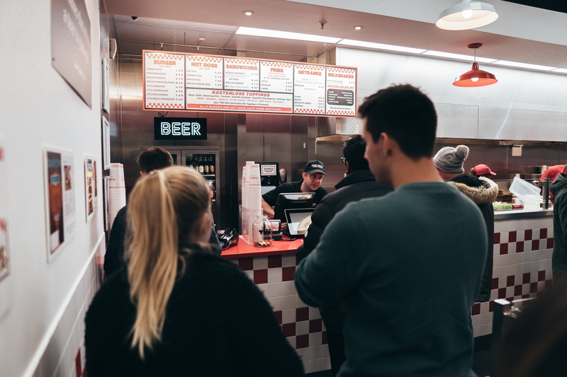 indoors, 5K, five guys, retail, bar counter, women, real people, rear view, burger, leisure activity, people, casual clothing, munich, fast food, hairstyle