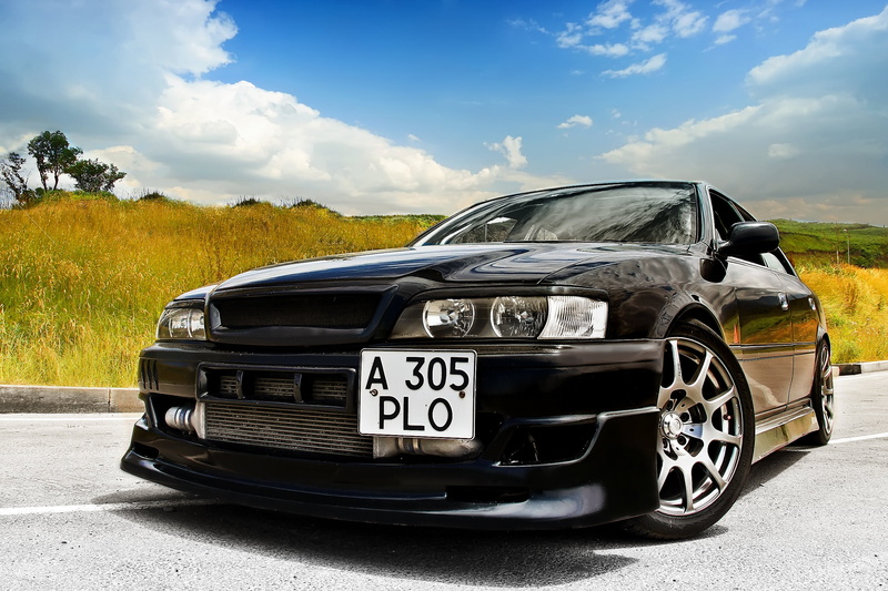 land vehicle, tree, day, plant, black, sunlight, Toyota, text, tayota, cloud - sky, car, outdoors, motor vehicle, stationary, sky, nature, street, chayzer