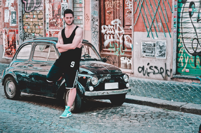 day, wear, full length, building exterior, adult, top, young adult, car, city, architecture, graffiti, brick, beside, athlete, 5K, outdoors, land vehicle