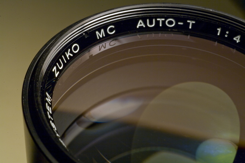 olympus, camera - photographic equipment, text, old, zuiko, studio shot, camera, communication, retro, indoors, antique, photography, technology, optical
