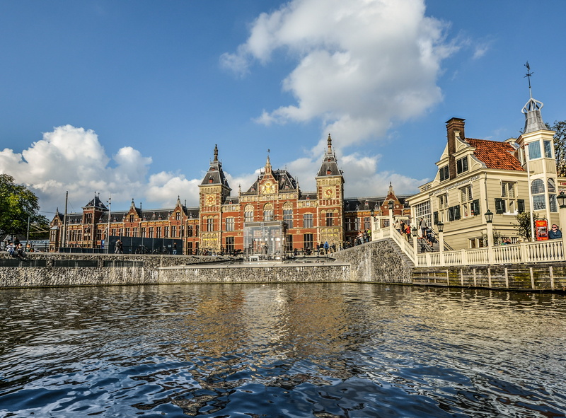 waterfront, river, canal, built structure, urban skyline, cloud - sky, facing, europe, netherlands, tourism, day, skies, amsterdam, cloudy, brown, railway station