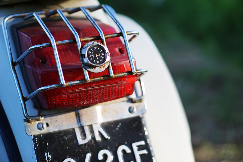 nature, western script, red, 8K, focus on foreground, fender, rear light, bike, single object, land vehicle, field, plate, machinery, taillight, close-up