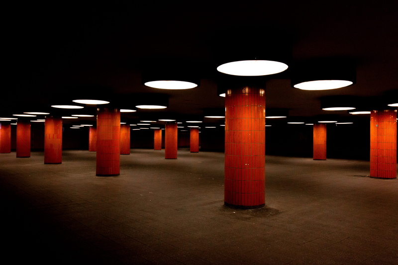 dark, modern, parking garage, empty, built structure, indoors, flooring, in a row, electric light, light fixture, atmosphere, columns, no people, architectural column