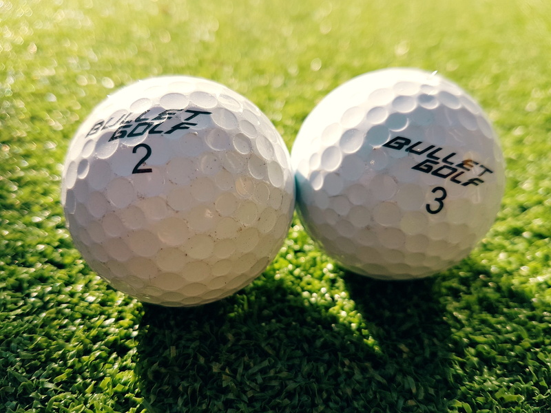 balls, activity, green color, close-up, white color, sport, plant, two, 4K, golf ball, bullet, golf, grass, golfing, black, leisure activity, focus on foreground