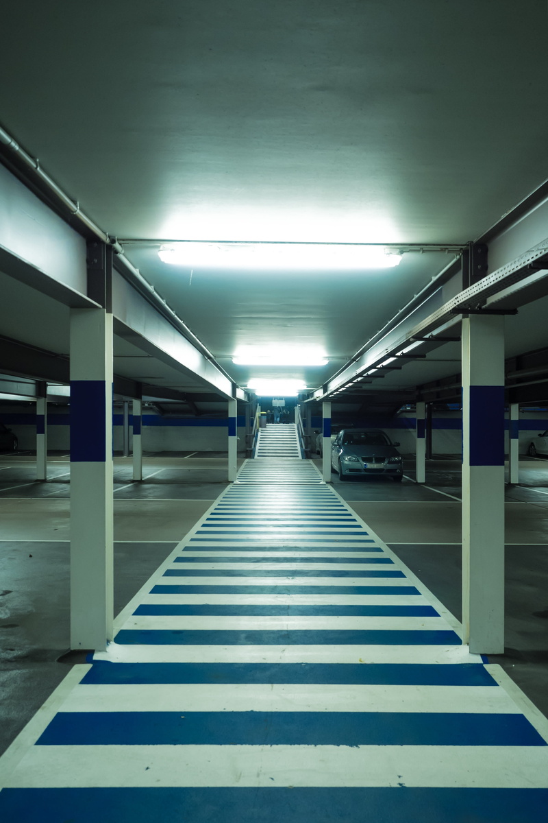 parking, tiled floor, lighting equipment, photo, indoors, arcade, pathway, area, no people, the way forward, blue, illuminated, corridor, architecture