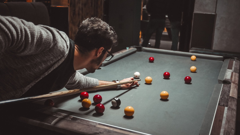 leisure activity, bending, game, hair, billiard room, human, cardigan, real people, ball, lifestyles, grey, holding, pool table, playing, furniture, indoors