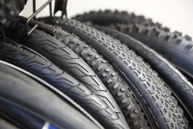 tire, black color, rubber, vehicle part, cycling, sport, selective focus, bike shop, 5K, industry, motorcycle, people, close-up, outdoors, transportation