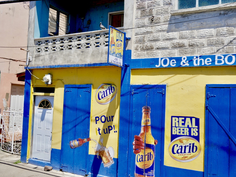 information sign, drink, urban, door, communication, wall, caribbean, bottle, poster, clothing, spoke, building, script, building exterior, architecture