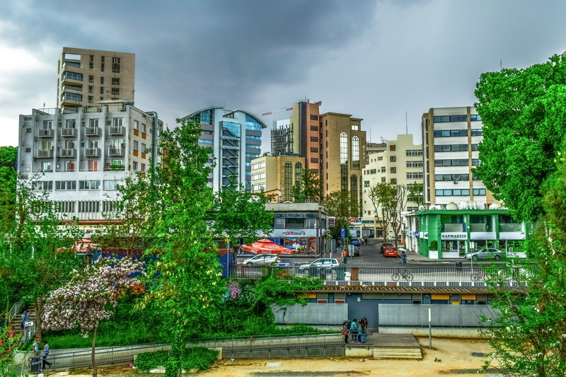 land vehicle, city, nicosia, tree, office building exterior, incidental people, rain, modern, cyprus, outdoors, built structure, cloud - sky, street, transportation