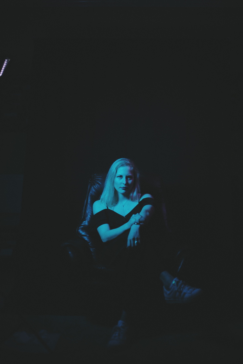 apparel, person, girl, night life, sitting, portrait, sofa, leisure activity, stage, real people, flourescent, lifestyles, light - natural phenomenon, dance pose