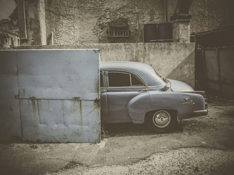 motor vehicle, vintage, garage, machine, architecture, wall, wheel, deterioration, ruined, screen, sports car, no people, dirt road, day, car, built structure