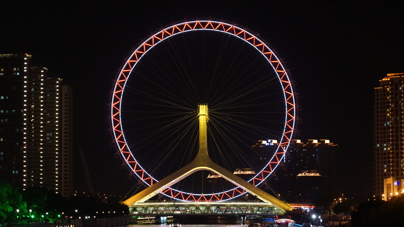 illuminated, hubcap, alloy wheel, nightlife, downtown, lighting, office building exterior, city, motion, sky, built structure, tire, urban, axle, travel