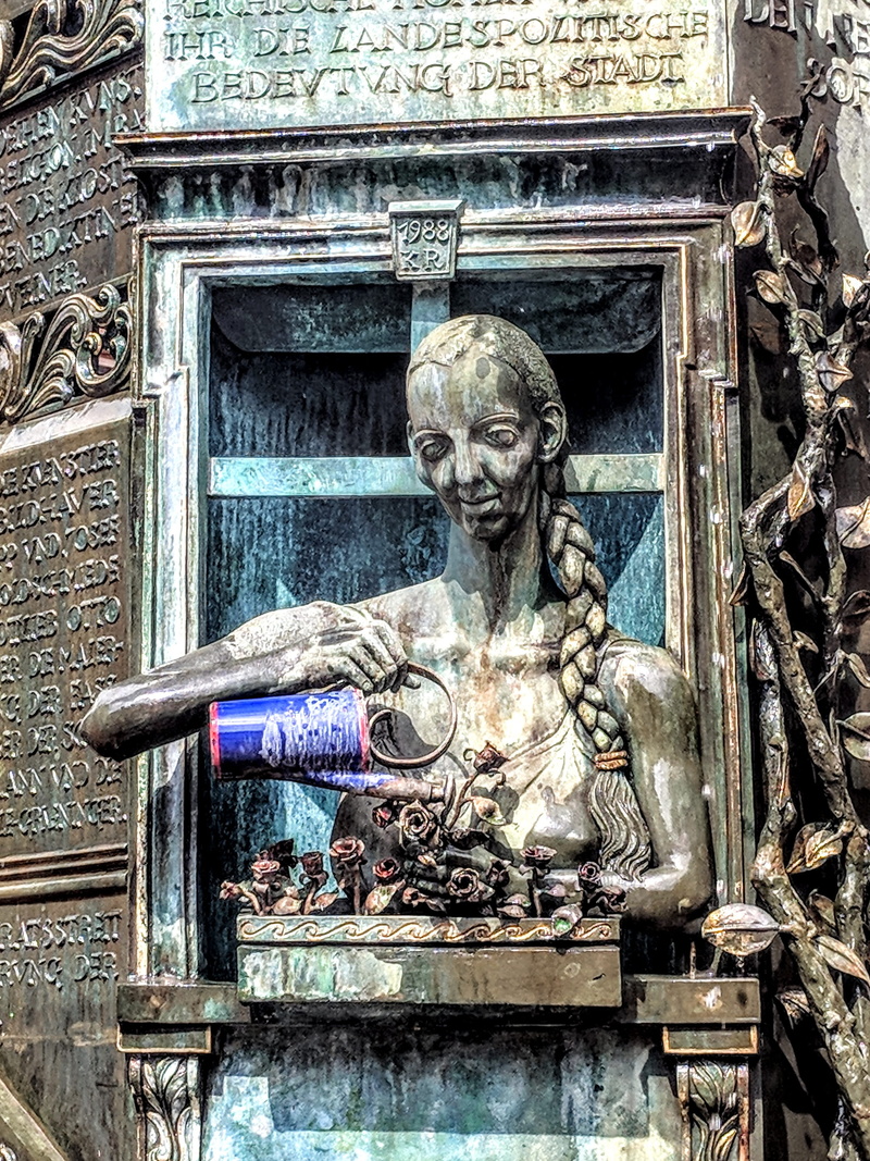 building, city, male likeness, history, day, architecture, female likeness, face, metal, font, artwork, artists, low angle view, human representation, figures