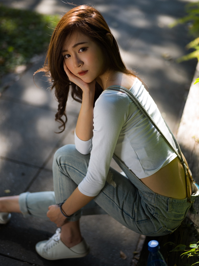 women outdoors, brunette, sitting, white tops, sidewalks, touching face, model, outdoors, women, portrait display, depth of field, looking at viewer, overalls