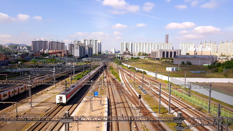 outdoors, city, building, shunting yard, mode of transportation, no people, landscape, rail transportation, transportation, high angle view, built structure