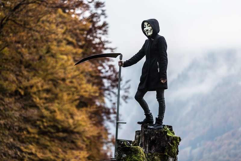 casual clothing, tree, full length, holding, fashion, creepy, hoodie, person, standing, side view, focus on foreground, outdoors, halloween, men, mask