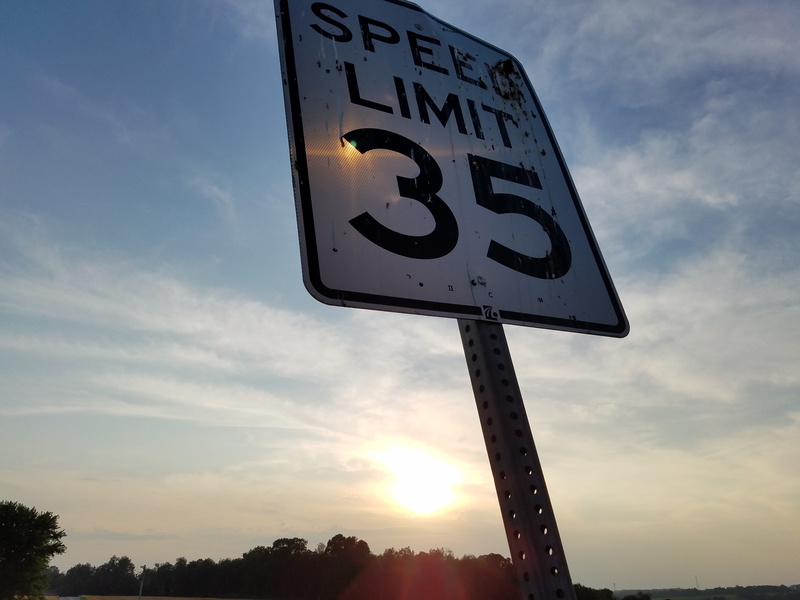 signage, slow, cloud - sky, limit, pole, tree, text, number, sunlight, nature, guidance, sky, western script, low angle view, speed, information, road sign