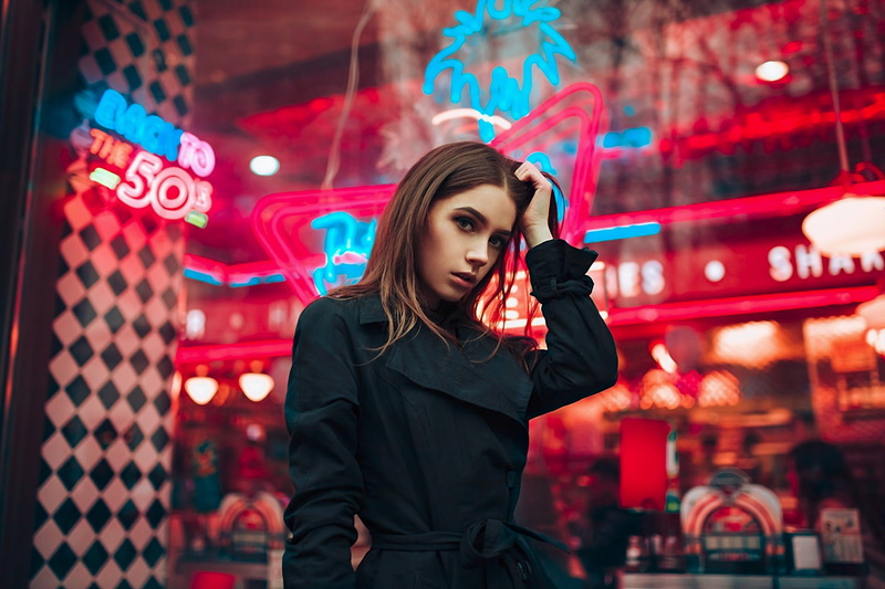 red, focus on foreground, young women, portrait, standing, open mouth, front view, illuminated, brown eyes, neon, architecture, one person, holding, night