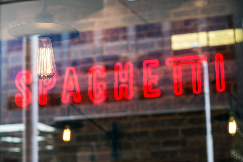 street, communication, sign, glowing, reflection, light, low angle view, architecture, outdoors, red, store sign, hanging, text, neon Light, focus on foreground