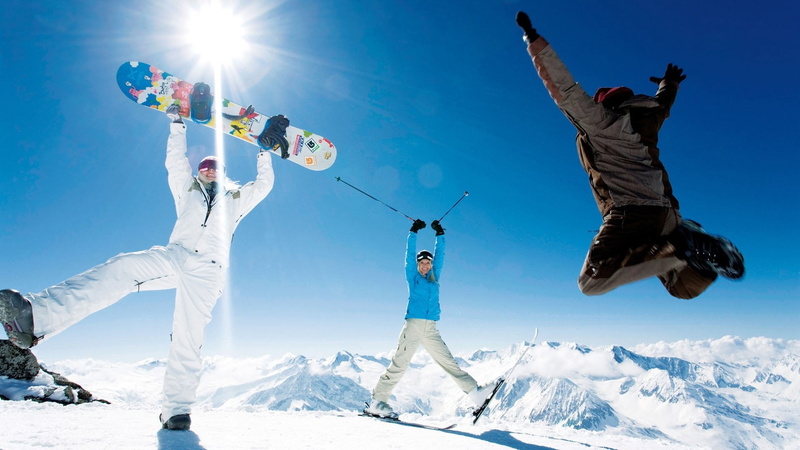skis, happiness, sunlight, motion, standing, fun, joy, adventure, arms raised, nature, winter sport, snowboard, smiling, males, day, jump, enjoyment, leisure activity