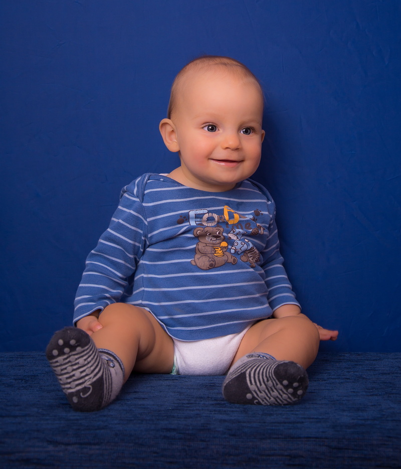 sitting, face, young, lucky soul, blue, small child, cute, live new, beautiful, portrait, laugh, smiling, view, indoors, family, blue background, childhood