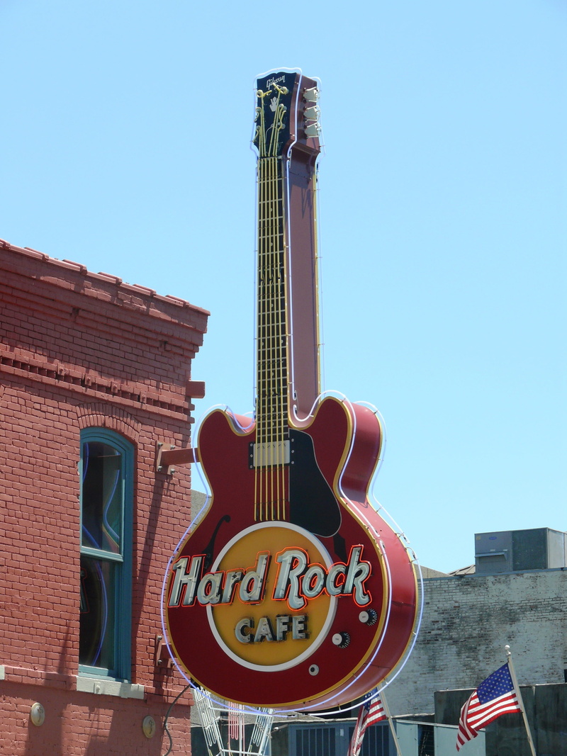 communication, western script, building exterior, string instrument, america, sky, office building exterior, usa, blue, sign, day, text, Guitar, outdoors