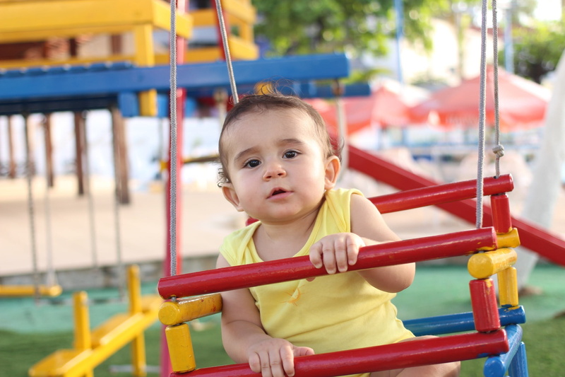 merry-go-round, one person, playing, fun, cute, portrait, looking at camera, innocence, focus on foreground, people, casual clothing, baby, babies only