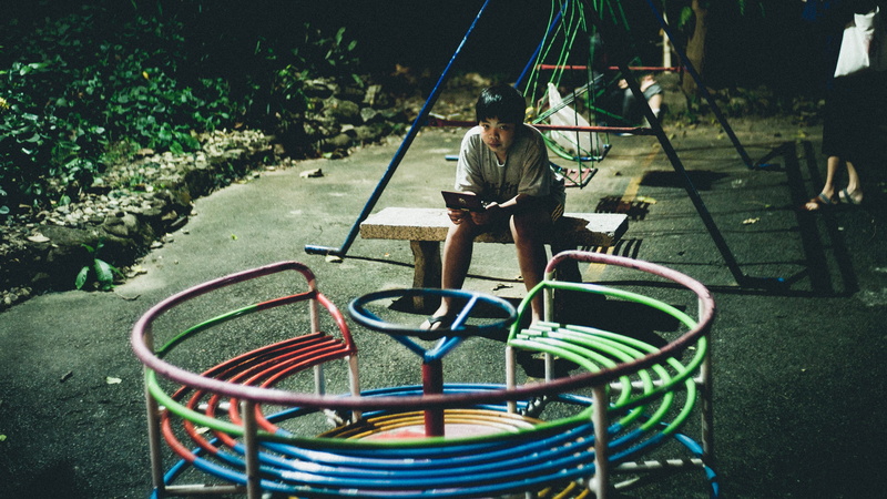 boys, sitting, merry go round, full length, park, day, girls, outdoor play equipment, outdoors, person, playground, multicolored, boy, reading, bench, holding