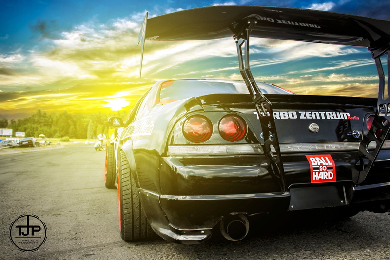 street, outdoors, text, sunset, car, sky, nature, road, stationary, western script, mode of transportation, 2K, reflection, motor vehicle, land vehicle
