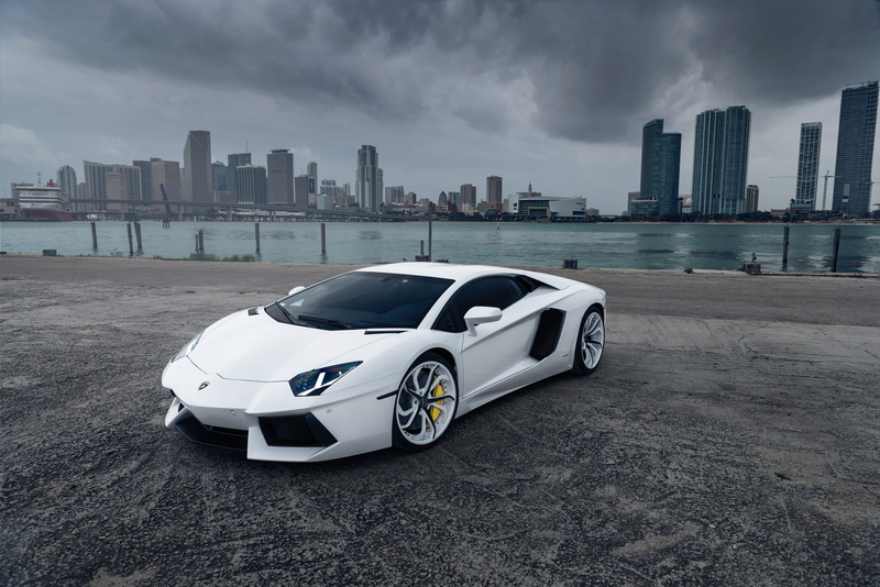 office building exterior, sports, Aventador, outdoors, luxury, 5K, street, cloud - sky, road, supercar, new, no People, urban skyline, city, sky, parking Lot