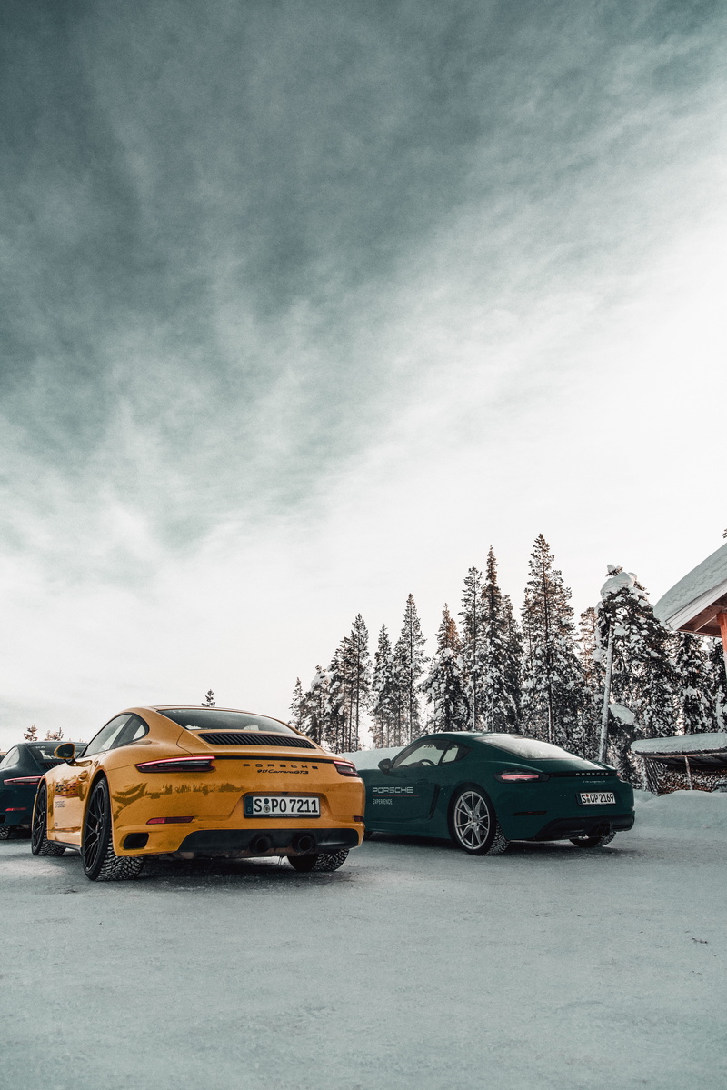 school bus, tire, porsche, motor vehicle, transportation, sports car, parking, cloud - sky, built structure, vehicle, sky, car, nature, coupe, road, license plate