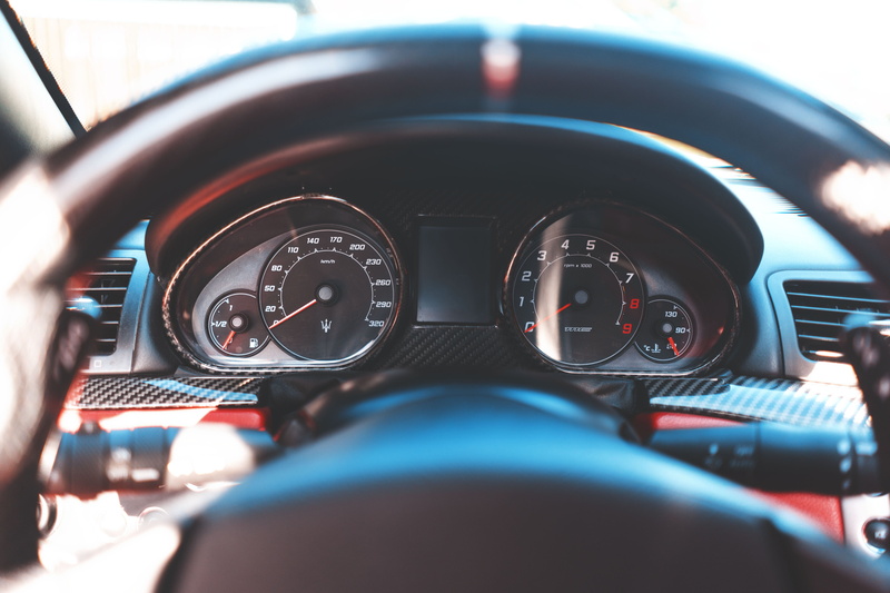 land vehicle, motor vehicle, transportation, car, human hand, control panel, sedan, gauge, car interior, vehicle, selective focus, close-up, control, speedometer