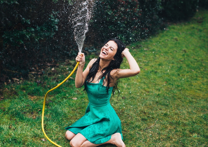dress, lifestyles, three quarter length, real people, land, leisure activity, casual clothing, water drops, outdoors, black hair, green dress, kneeling