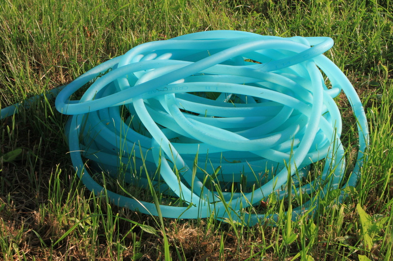 high angle view, tools, 4K, green color, day, pipe, grass, green, outdoors, rubber, land, no people, reel, garden, field, blue, nature, wood - material