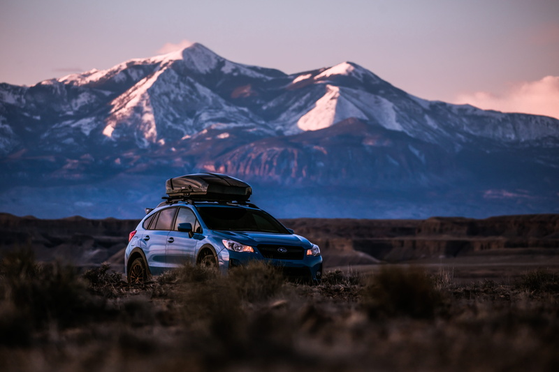 blue, land, offroad, road, vehicle, outdoors, mountain range, environment, snowcapped mountain, beauty in nature, car, race car, roof rack, field, coupe