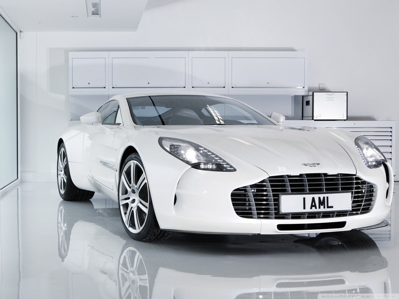 mode of transportation, wealth, showroom, car dealership, indoors, motor vehicle, Aston Martin, retail, land vehicle, luxury, stationary, white color, front view