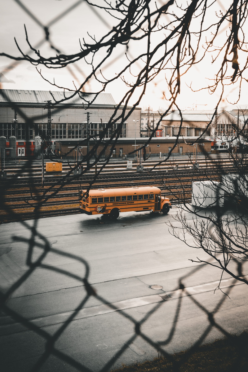 truck, intersection, vehicle, road, mode of transportation, van, barrier, car, spire, sky, land vehicle, built structure, outdoors, city, sunlight, bus