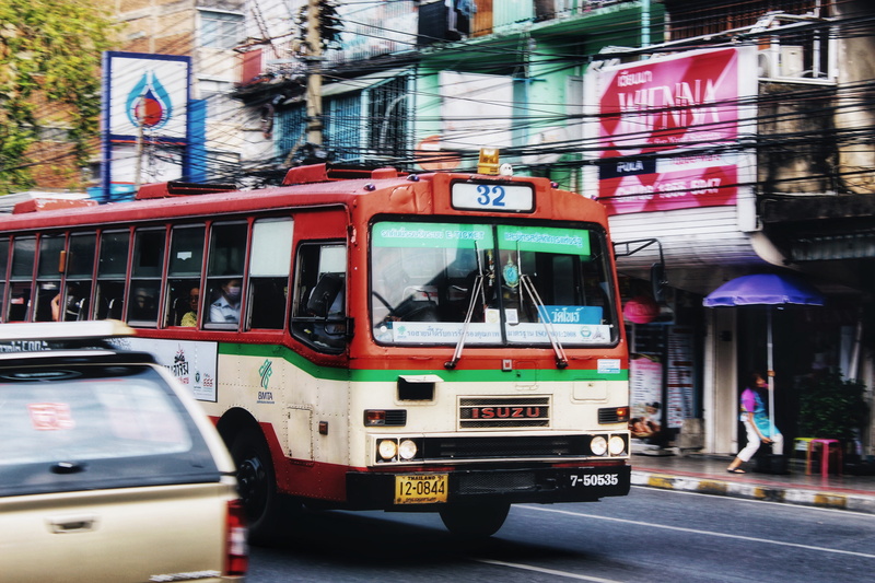 vehicle, street, cable car, mode of transportation, city, building exterior, van, real people, motor vehicle, red, truck, communication, minibus, text