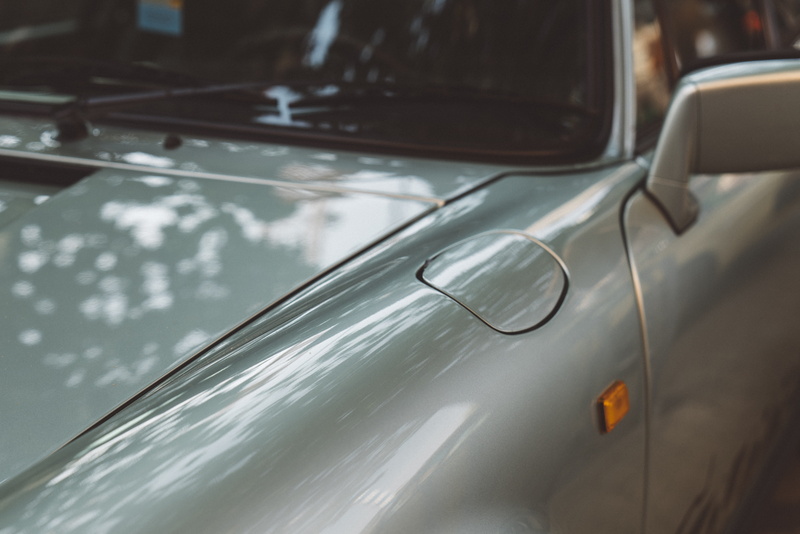 car mirror, cars, symbol, land vehicle, motion, porsche, nature, trademark, windshield, gray, reflection, logo, headlight, day, tire, no people, indoors