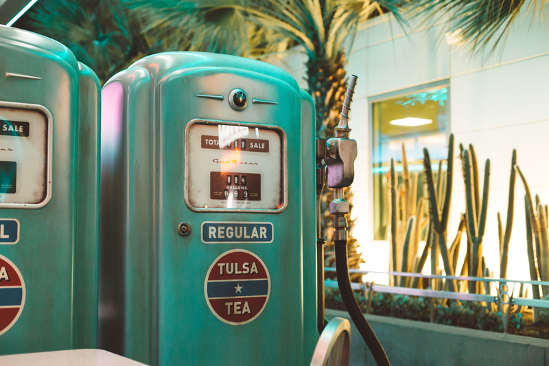 sign, gas station, gas, gallons, sale, fuel pump, mode of transportation, day, transportation, palm tree, train - vehicle, station, machine, communication