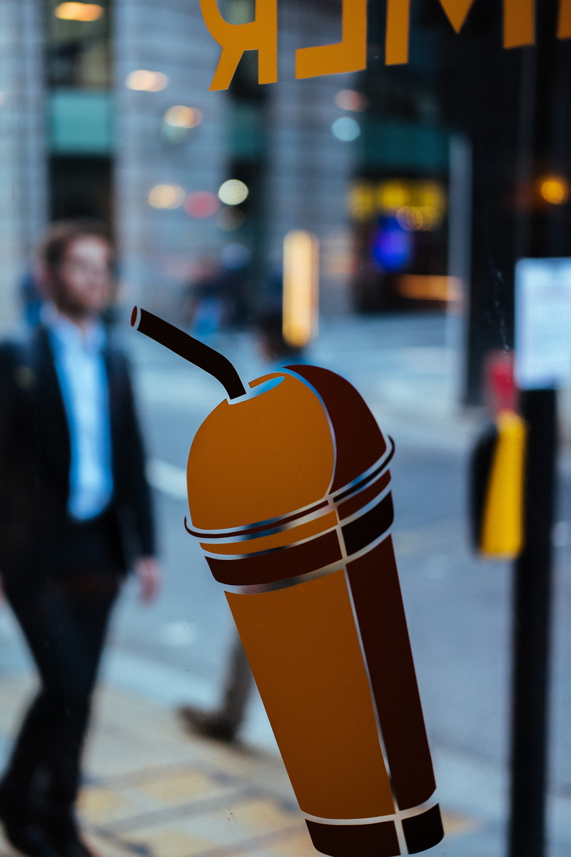 sticker, vinyl, shallow, typography, orange, holding, brown, cup, real people, container, street, men, straw, blur, signage, sticked, incidental people