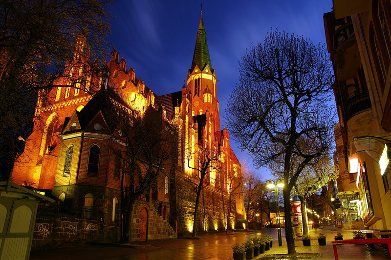 christianity, spire, landmark, road, bruges, building, beside, tree, house, monument, dusk, downtown, urban, light, sky, night, city, evening, dawn, bare tree