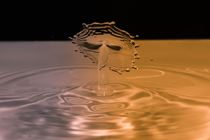 splashing droplet, purity, splashing, waterfront, 5K, no people, orange, tat, high-speed photography, studio shot, drop, reflection, concentric, black background
