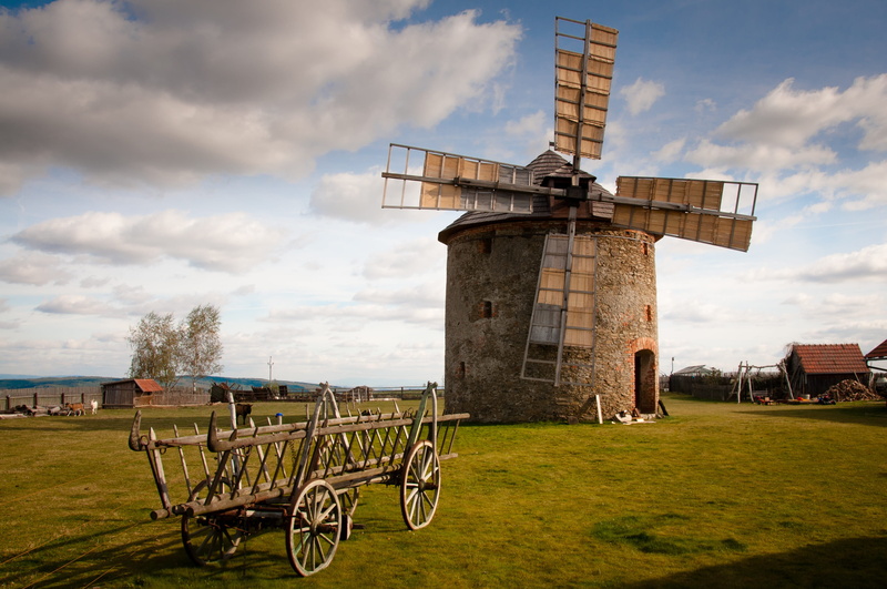 architecture, car, building exterior, plant, land, outdoors, grass, built structure, gray, unesco, wind power, nature, flour, traditional windmill, field