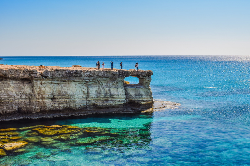 scenery, sea, clear sky, cliff, scenic, nature, tourism, window, cavo greko, beauty in nature, horizon, rock, nature landscape, group of people, water